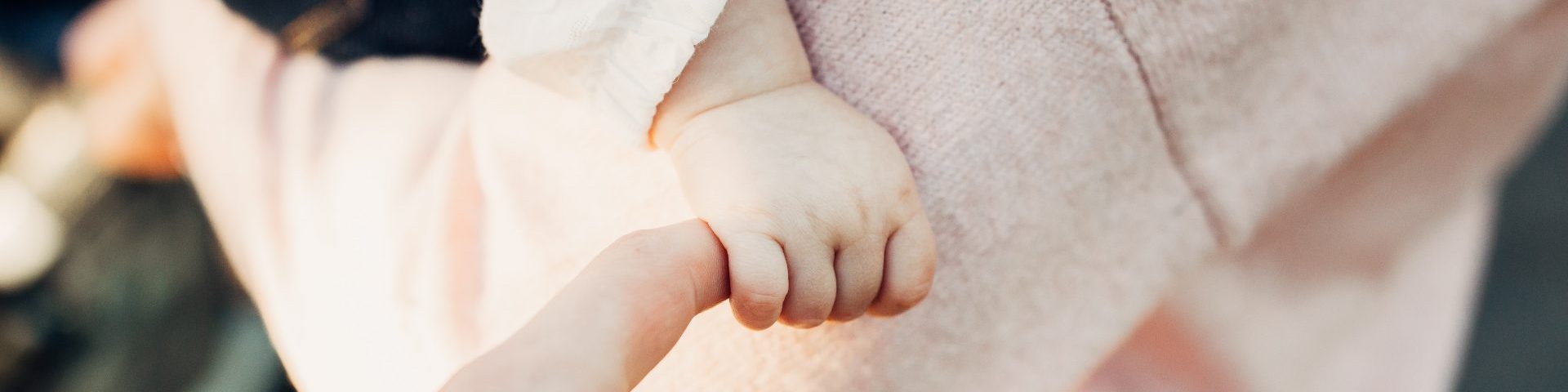 joshua-reddekopp-qLFJKFBppPM-unsplash person holding baby's hand